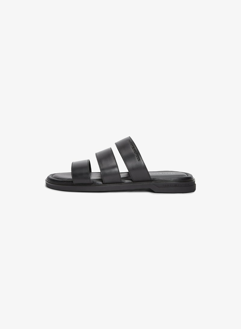 Sandale slide noire avec trois larges lanières en cuir et une semelle plate, conçue pour un usage décontracté.