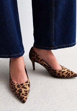 Décolleté a stampa leopardata con punta appuntita e tacco a spillo di 5 cm, realizzate in morbido tessuto. Indossate con jeans scuri a gamba larga.