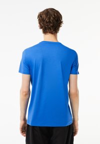 Blå kortærmet T-shirt lavet af blød stof; rund hals med en glat overflade. Skjorten har en tætsiddende design, velegnet til afslappet brug.