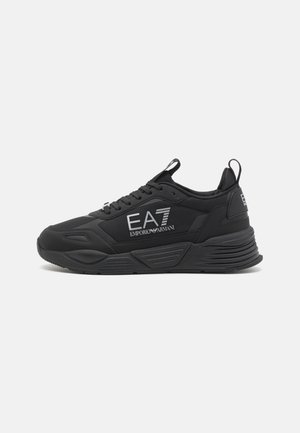 Baskets basses noires pour le sport avec semelle épaisse, lacets, languettes de tirage, et logo "EA7 Emporio Armani" sur le côté et le talon.