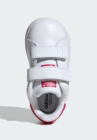 White sneaker with two Velcro straps, smooth leather upper, red accent on heel, cushioned interior, and classic Adidas branding.