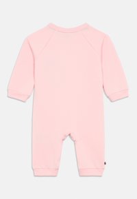 Body din bumbac roz deschis, cu mânecă lungă, cu manșete știrbite și decolteu rotund. Prezentă un mic logo pe lateral.