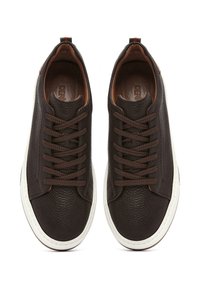 Zapatillas de cuero marrón con superficie texturizada, puntera redonda y diseño de cordones. Suela de goma blanca con acentos marrones y logotipo en la plantilla.