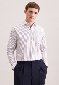 Camicia a righe bianca e rosa chiaro, colletto abbottonato, maniche lunghe, vestibilità classica. Abbinata a pantaloni blu navy.