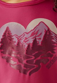 Camiseta de tela rosa con un gráfico en forma de corazón que presenta montañas y árboles texturizados de glitters, incorporando tonos de púrpura y rojo.