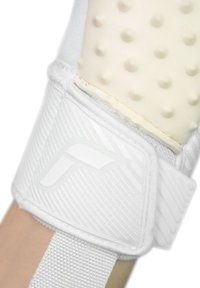 Gant de sport blanc avec rembourrage en caoutchouc texturé et une sangle Velcro. Présente des rainures subtiles et une finition lisse du matériau.