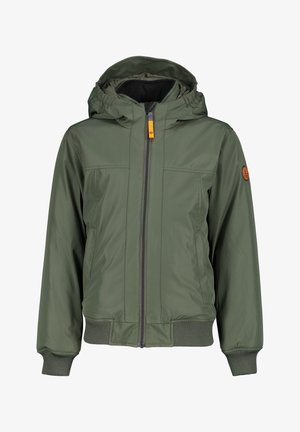 Chaqueta acolchada verde oliva con cremallera frontal, puños acanalados y parche con logo en la manga, combinada con jeans grises y zapatillas blancas.