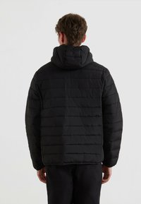 Giacca a vento nera con texture trapuntata orizzontale e cappuccio. Presenta una vestibilità rilassata e polsini elastici. Finitura liscia e opaca.