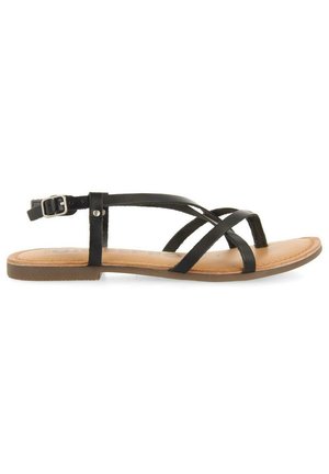 Sandali in pelle nera con molteplici cinturini, fibbia regolabile alla caviglia e suola piana color tannico. Design semplice con una texture liscia.