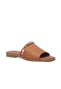 Tan leather slide sandals with an open toe, featuring a rounded shape and a decorative silver-accented strap across the vamp.