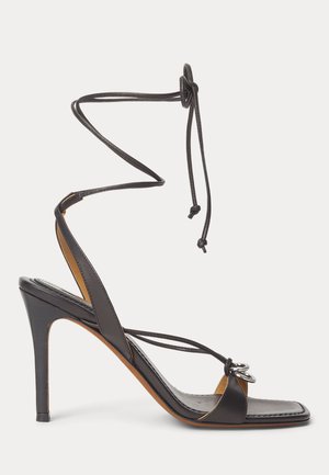 Sandale negre din piele cu toc înalt, bretele subțiri, legături în jurul gleznei, vârf pătrat și decorațiune argintie cu dublu inel pe breteaua din față.