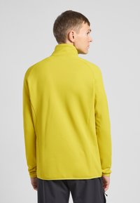 Geel, langmouwige pullover met hoge kraag. Glad textuur en atletische pasvorm, met naden en een rechte zoom.