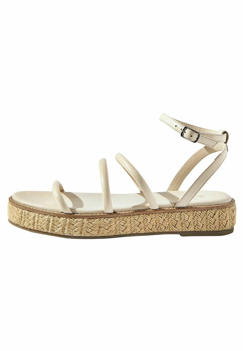 Sandale plateforme beige avec trois fines brides, une fermeture à boucle et une semelle en jute tissée. Matériau lisse avec une base texturée.