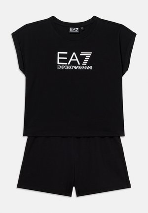 Μαύρο cropped τοπ με κοντά μανίκια και λευκό λογότυπο EA7 Emporio Armani, συνδυασμένο με μαύρο σορτς σε λευκό φόντο.