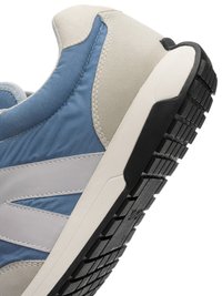 Close-up of a blue, gray, and beige sneaker heel showing stitched fabric details and a textured black rubber sole.
