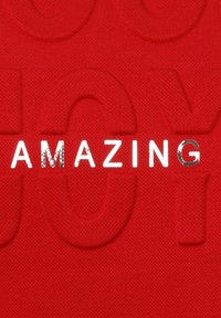 Red fabric featuring embossed lettering reading "AMAZING" in shiny silver, with a textured background and subtle patterned accents.