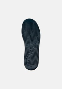 Plantilla de zapato de goma negra con superficie texturada que presenta surcos curvados y el logo estampado "CAMPER", talla 42 indicada en el talón.