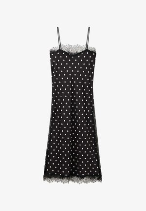 Czarna midi sukienka na ramiączkach w białe groszki, cienkie ramiączka i koronkowe wykończenie przy dekolcie i na dole.