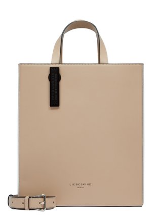 Beige leather tote bag with a structured shape, top handles, and a detachable belt. Features a black tag with "LIEBESKIND" embossed.