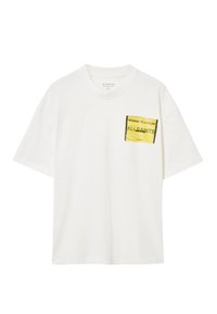 Hvid bomulds t-shirt med rund hals og korte ærmer. Har et gult grafisk lomme-design med tekst på venstre side.