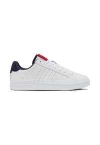 Zapatilla blanca con diseño perforado, acentos en rojo y marino en el cuello, y el estampado en dorado "1966". Material de cuero suave y suela de goma.
