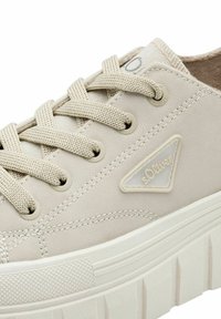 Sneaker beige con superiore sintetico testurizzato, lacci in cotone piatti e suola in gomma bianca con design scanalato. Include un accento con logo.