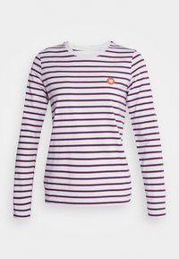 Långärmad t-shirt i vitt med lila ränder, med en liten orange logga på bröstet. Material av bomull, rund halsdesign.