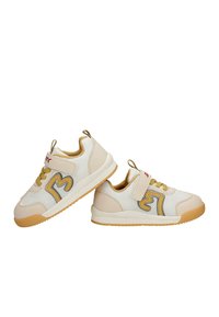 Paire de baskets pour enfants beiges et blanches avec des bandes Velcro, des accents jaunes, et des semelles en caoutchouc texturées, présentées sur un fond blanc.