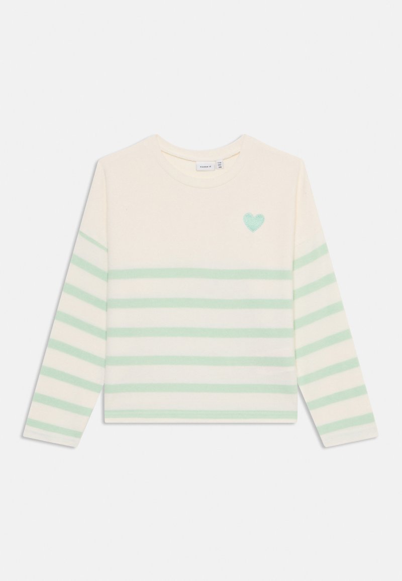 Suéter de punto a rayas en color crema con rayas horizontales en verde claro, cuello redondo y un pequeño detalle de corazón verde en el pecho. Textura suave.