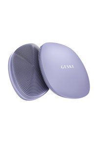 Lilla hårbørste med et afrundet design, der har en tekstureret overflade og tætte, fleksible børstehår. Mærket "GESKE" er præget på toppen.