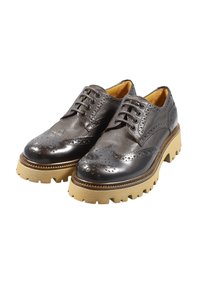 Scarpe in pelle grigia scura con design brogue, caratterizzate da dettagli perforati e suola in gomma crepe con profilo chunky.