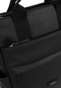 Zwarte laptoptas met een zachte, gestructureerde buitenkant, voorzien van verstelbare schouderbanden, meerdere ritszakken en versterkte naden voor duurzaamheid.
