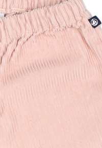 Pantaloni per bambini rosa chiaro in tessuto a costine, dotati di una cintura elastica e di una piccola etichetta con logo di lato.