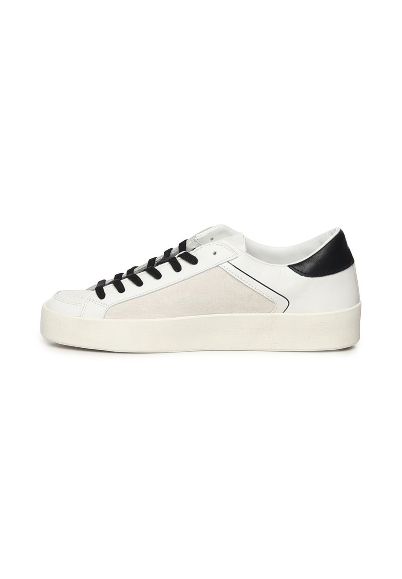 Witte leren sneaker met zwarte accenten, voorzien van een suède paneel en zwarte veters. Laag profiel ontwerp met een dikke witte rubberen zool.