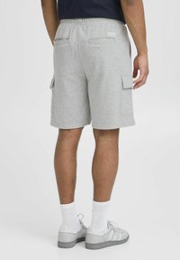 Graue Baumwoll-Cargo-Shorts mit einem Kordelzugbund, zwei Seitentaschen und Gesäßtaschen; glatte Textur und knielanges Design.