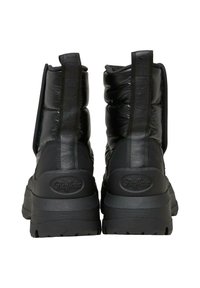 Botas de tobillo negras y abullonadas con un acabado texturizado, que cuentan con un logo elevado en la parte trasera, una suela de plataforma gruesa y lengüetas de tirón verticales.