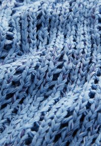 Tessuto lavorato a maglia di un blu chiaro con un motivo tessuto testurizzato. Presenta filamenti spessi e una trama leggermente allentata per favorire la traspirazione.