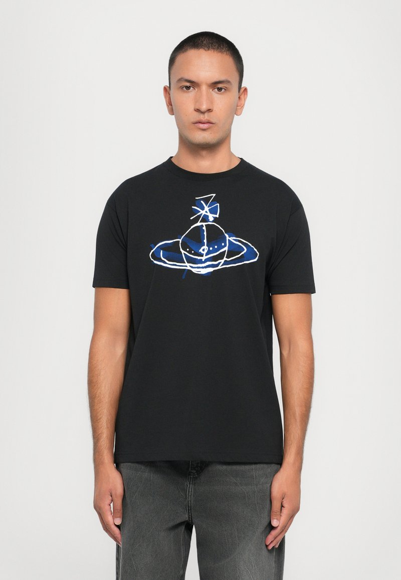 T-shirt en coton noir avec un graphique coloré d'une planète stylisée avec des anneaux, souligné en bleu, sur un fond uni.