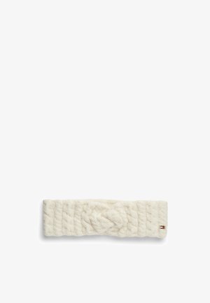 Kremfarvet strikket pandebånd med kabelmønster og et lille rektangulært rødt, hvidt og blåt logomærke på den ene side.