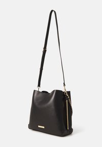 Czarna skórzana torebka na ramię o gładkiej fakturze, złote akcenty metalowe i odpinany pasek. Charakteryzuje się luźnym krojem oraz bocznym zamkiem błyskawicznym.