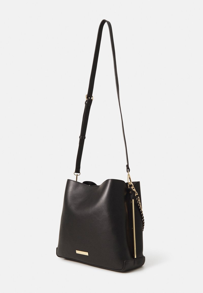 Czarna skórzana torebka na ramię o gładkiej fakturze, złote akcenty metalowe i odpinany pasek. Charakteryzuje się luźnym krojem oraz bocznym zamkiem błyskawicznym.