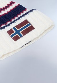 Berretto lavorato a maglia bianco con strisce rosse e blu navy, arricchito da una toppa bordeaux con un motivo di bandiera blu e bianca. Materiale strutturato e caldo.