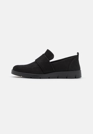 Chaussure noire à enfiler avec une large bride sur le dessus, semelle plate épaisse et languette à l'arrière du talon.
