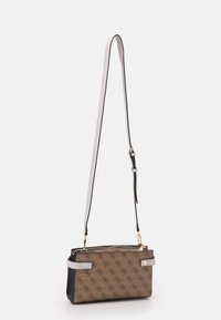 Brun mønstret crossbody-taske med sort bund, med en aftagelig hvid skulderrem og guldfarvet lynlås.