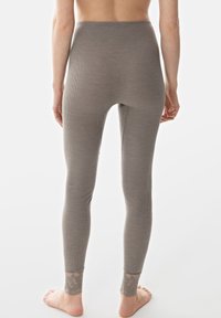 Graue Ripp-Leggings mit hoher Taille und transparenten Spitzendetails am Knöchel. Glatte Textur, figurbetontes Design, knöchellang.