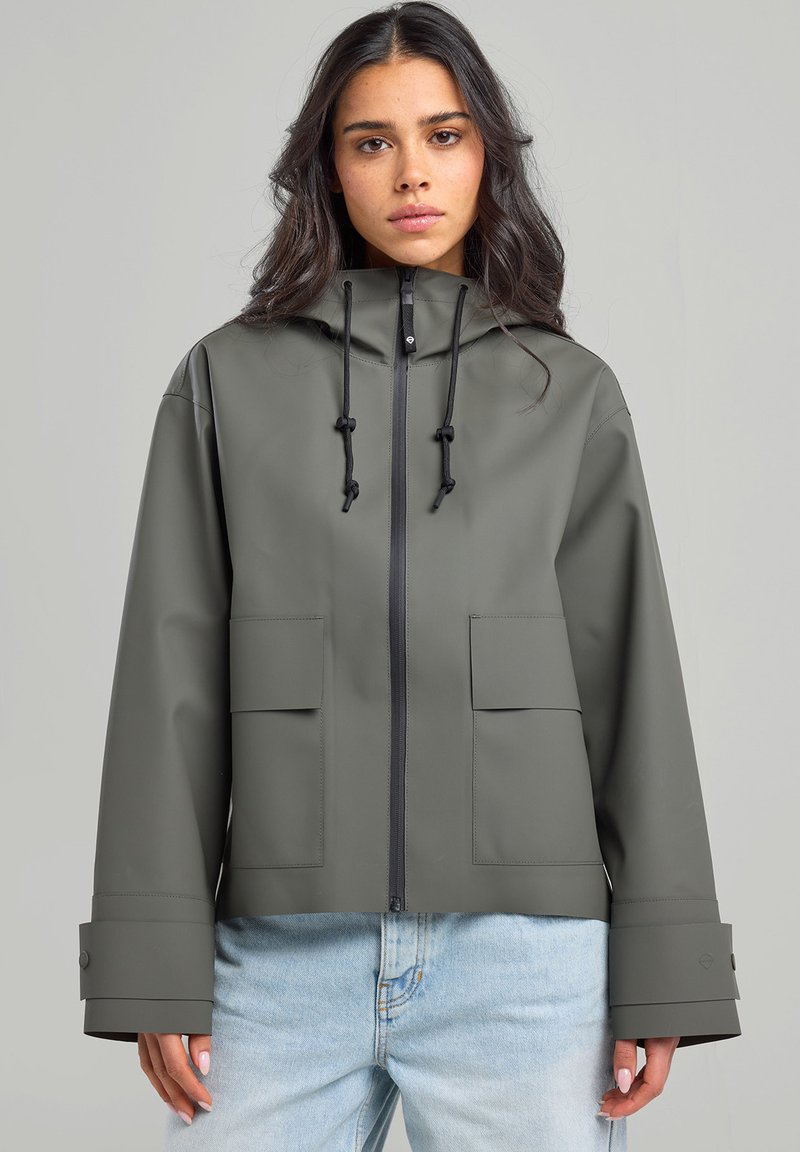 Gray waterproof jacket with a hood, front zip, and two large pockets. Features adjustable drawstrings and wide cuffs. Smooth texture.