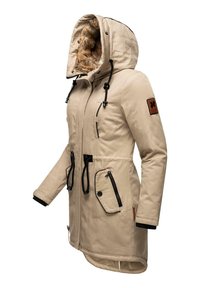 Parka beige con cappuccio foderato in pelliccia sintetica, tasche con zip nere, cordini regolabili e un'applicazione sulla manica. Tessuto testurizzato.