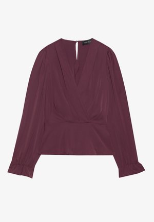 Blusa de manga larga en ciruela con escote en V, cierre en la parte delantera tipo wrap, puños fruncidos y un pequeño cierre de botón con ojal en la parte trasera del cuello.