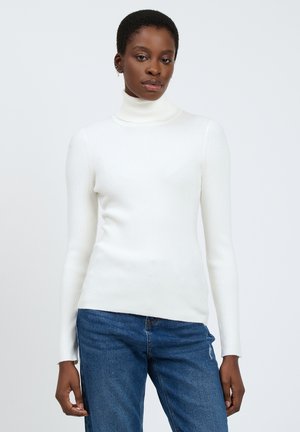Gerippter weißer Rollkragenpullover mit langen Ärmeln. Weiche Textur; enganliegendes Design. Kombiniert mit blauen Jeans.