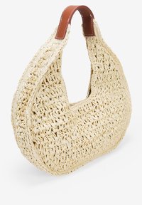 Bolso de paja tejido en forma de media luna, con una correa de cuero marrón lisa. El bolso es de color crema claro con un acabado texturizado.